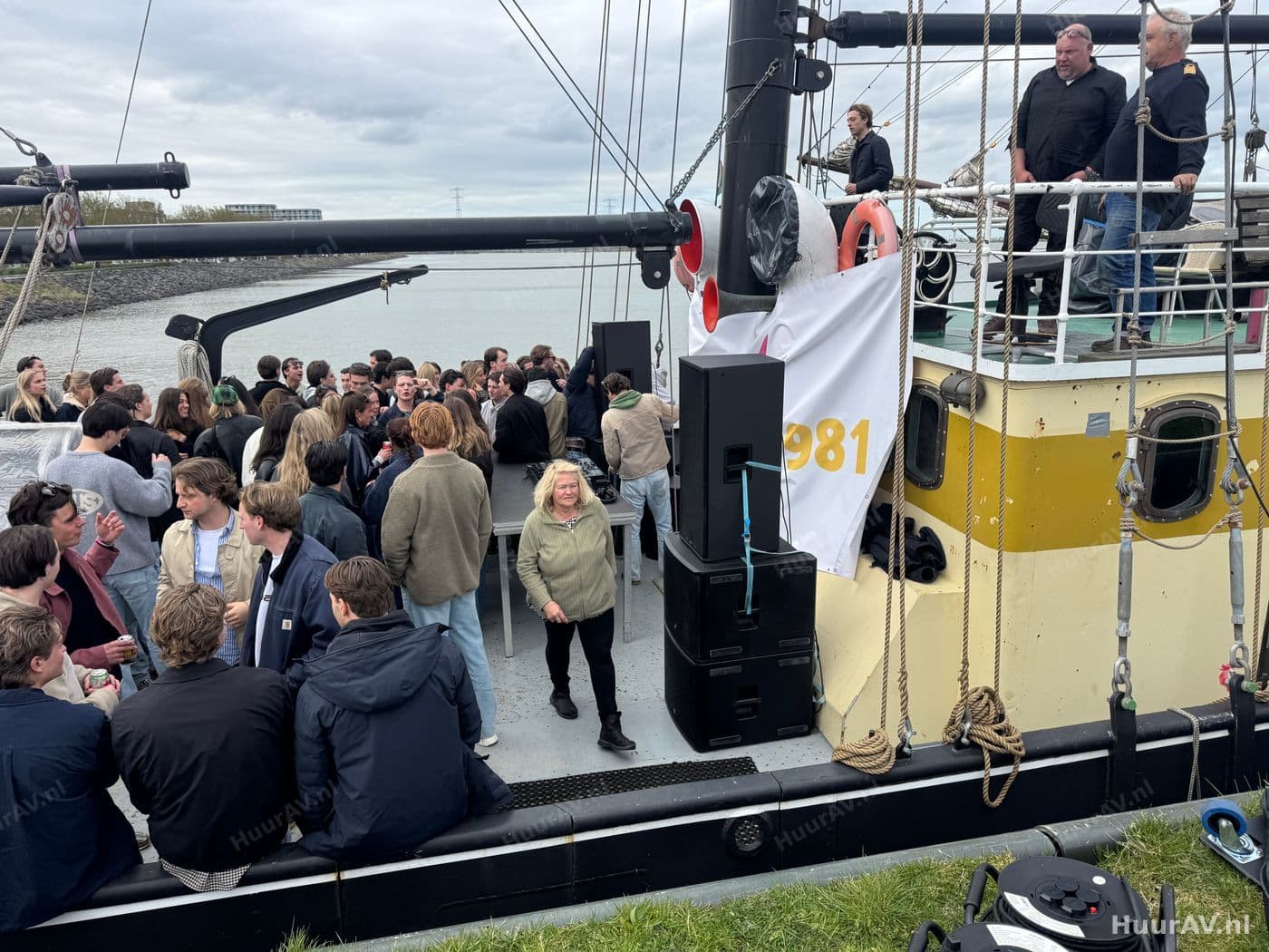 Feest op een partyboot op de Amsterdamse grachten met gasten, sfeerlicht en een compacte geluidsset aan boord
