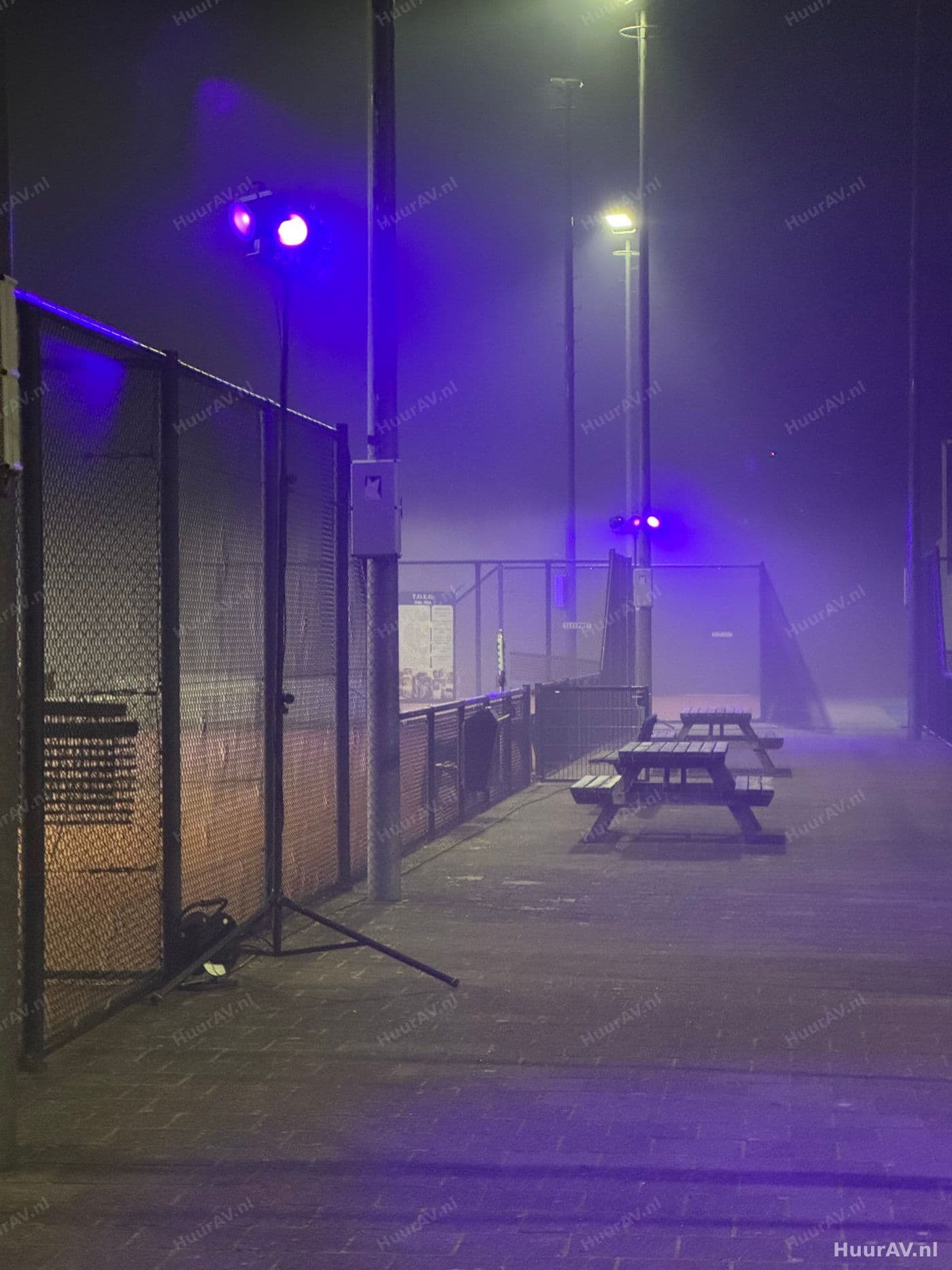 Feestzaal in Amsterdam met warme uplighting langs de wanden en gekleurd licht boven de dansvloer